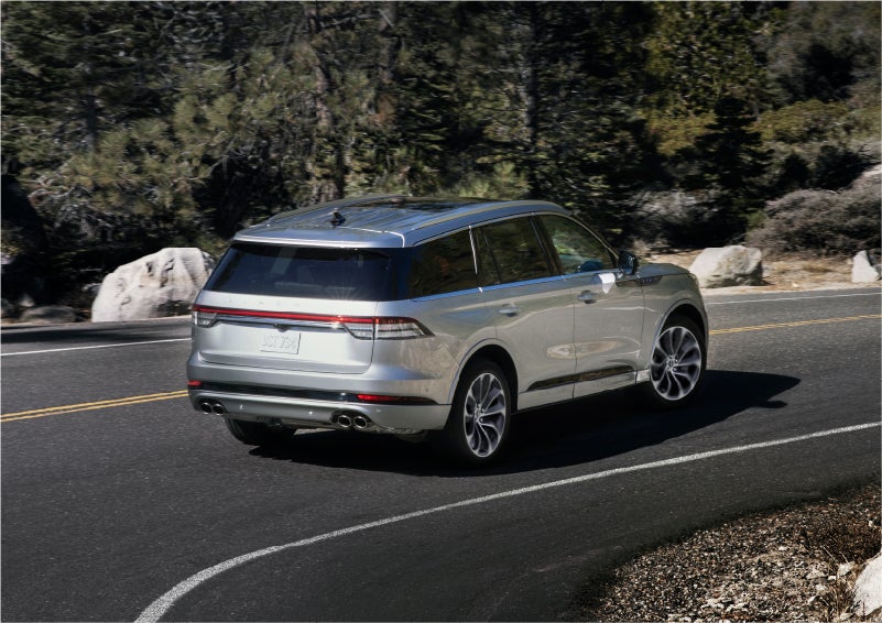 A 2023 Lincoln Aviator® Grand Touring model is shown being driven on a tight turn of a mountain road | Doggett Lincoln of Beaumont in Beaumont TX