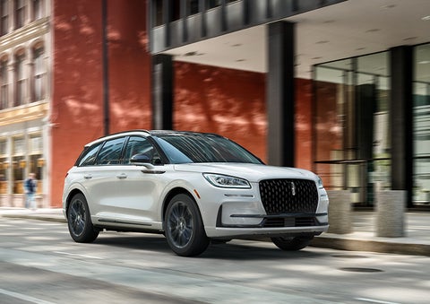The 2024 Lincoln Corsair® SUV with the Jet Appearance Package and a Pristine White exterior is parked on a city street. | Doggett Lincoln of Beaumont in Beaumont TX