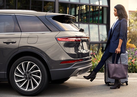 A woman with her hands full uses her foot to activate the available hands-free liftgate. | Doggett Lincoln of Beaumont in Beaumont TX